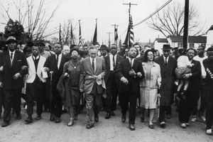 Martin Luther King marchează cu civili pentru drepturile civile.