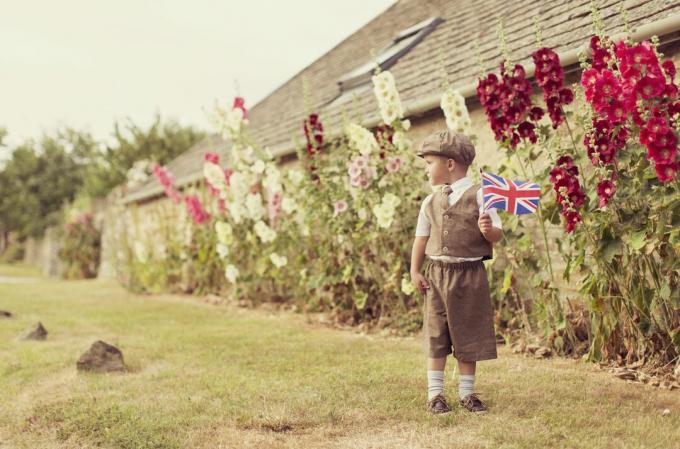 Băiatul britanic vintage care stă cu Union Jack