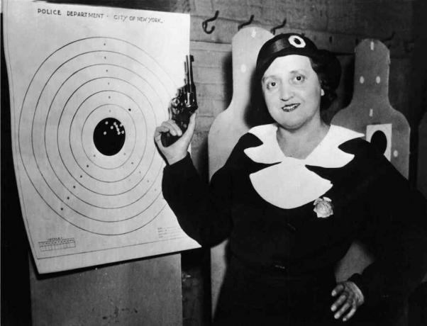 Una dintre cele 105 femei de poliție din New York stă cu arma și ținta ei la raza de tragere a poliției, New York, 12 decembrie 1934.