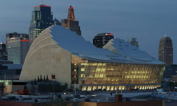 Fotografia de presă a Kauffman Center Hall și a terasei, seara, Kansas City în fundal.