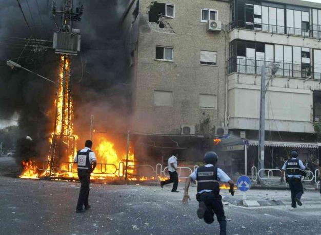 Polițiștii israelieni s-au repezit la locul unui pilon de electricitate care a ars și a deteriorat clădirile la câteva momente după ce un voleu de rachete Hezbollah a lovit 13 iulie 2006 în orașul Nahariya, în nordul Israelului.