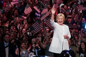 Hillary Clinton se învârte în fața mulțimii de oameni care flutură steagurile S.U.A.