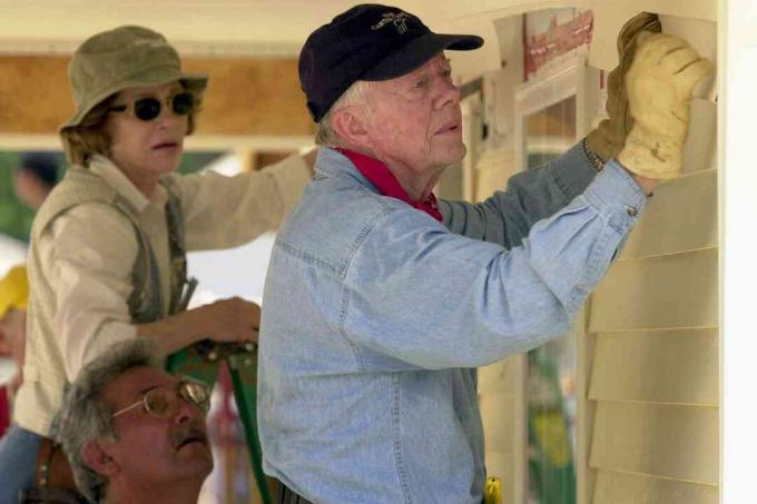 Fostul președinte american Jimmy Carter și soția sa, Rosalyn, atașează pardoseala în fața unei case Habitat for Humanity construită pe 10 iunie 2003 în LaGrange, Georgia.