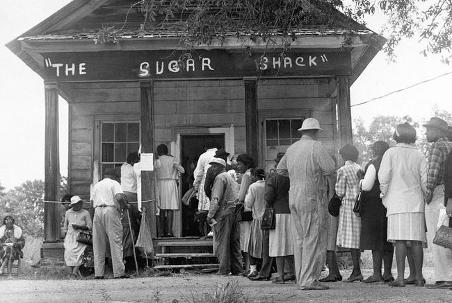 Alegătorii afro-americani, capabili să voteze pentru prima dată în mediul rural Wilcox County, Alabama, se aliniază în fața unei secții de votare după adoptarea legii federale privind drepturile de vot în 1965.