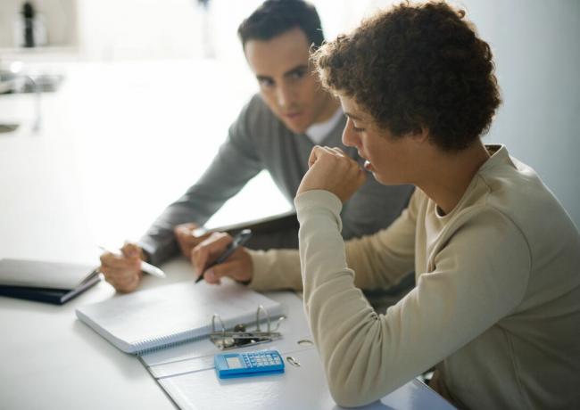 Tatăl care ajută fiul adolescent cu temele