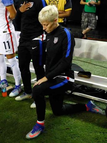 Fotografie cu vedeta de fotbal a femeii, Megan Rapinoe, îngenuncheată în timpul imnului național