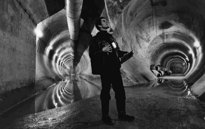 Un bărbat care stă într-un punct în care două tuneluri se conectează în Chunnel.