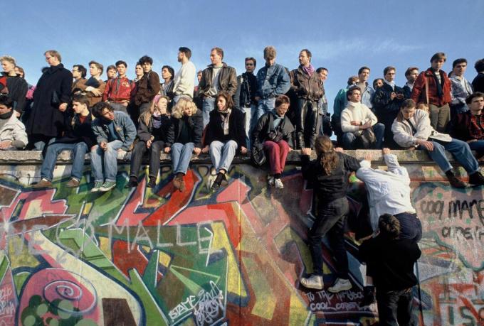 Oamenii se urcă pe Zidul Berlinului pe 10 noiembrie 1989, în sărbătoare.