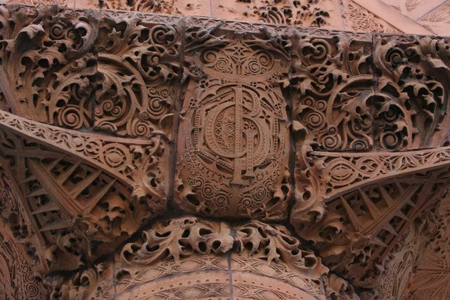 detalii de terasă sculptate maro, bucle ornamentate și monogramă GB