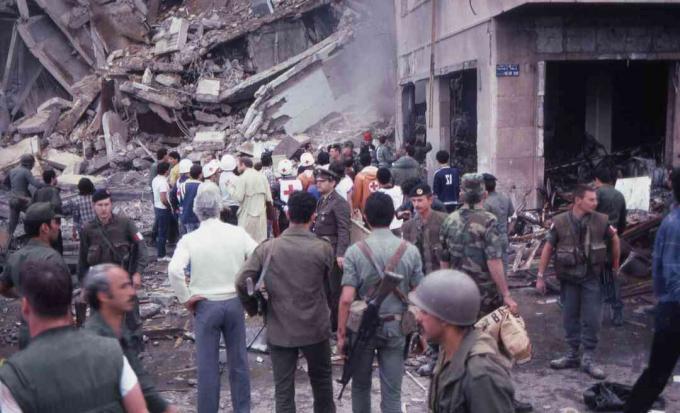 O mulțime de soldați și asistenți stau în mijlocul distrugerii și pagubelor la locul atentatului sinucigaș al Ambasadei americane, Beirut, Liban, 18 aprilie 1983.