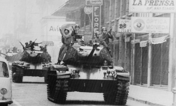 Soldații călăresc pe tancuri pe străzile din Santiago, Chile, în timp ce generalul armatei Augusto Pinochet este jurat ca președinte.