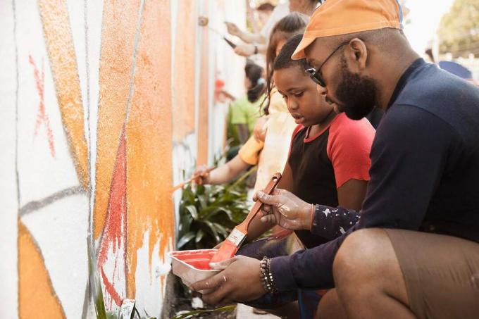 Oamenii pictează peretele împreună