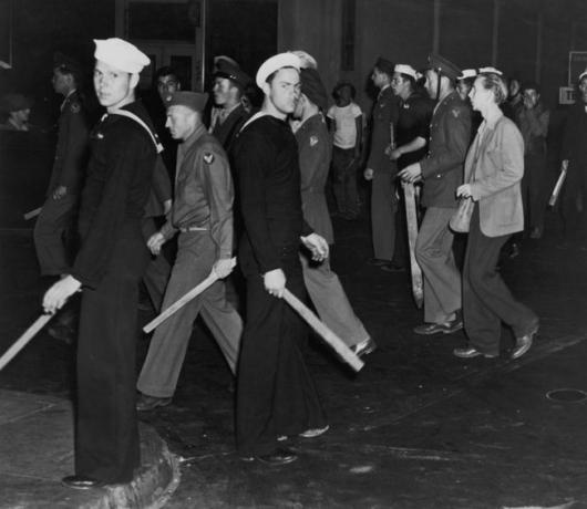 Bande de marinari și marinari americani înarmați cu bastoane în timpul revoltelor Zoot Suit, Los Angeles, California, iunie 1943.