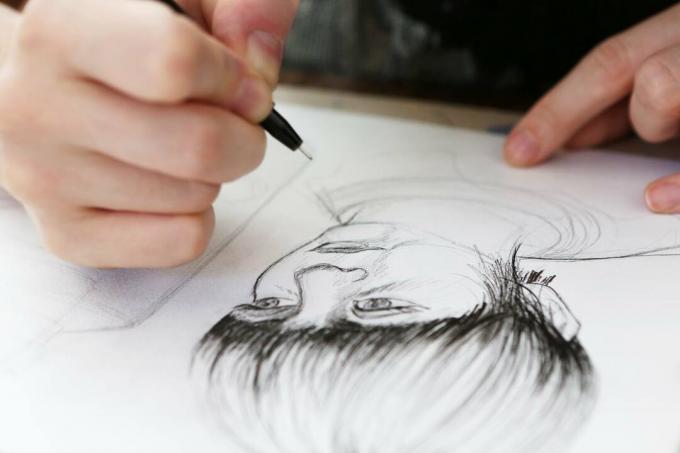 Un ilustrator care lucrează la un desen